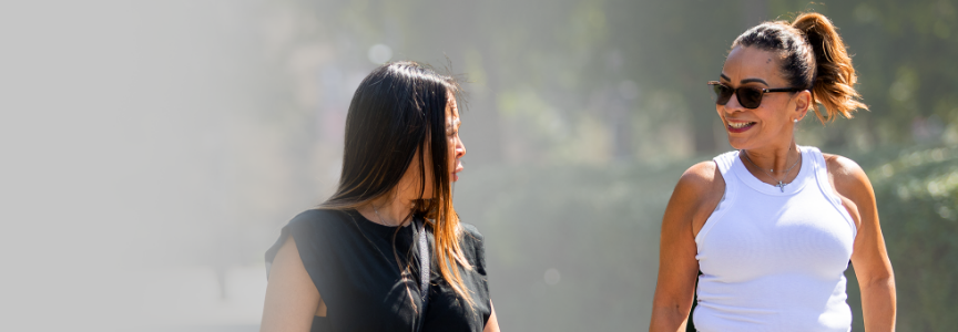 Two women on a walk together outside.